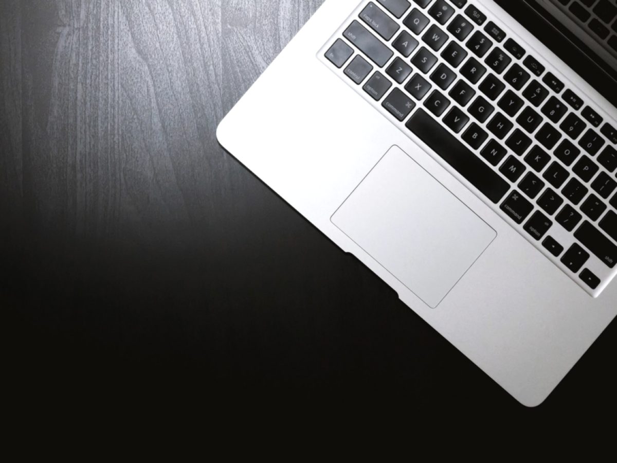 Open laptop on a dark wooden desk